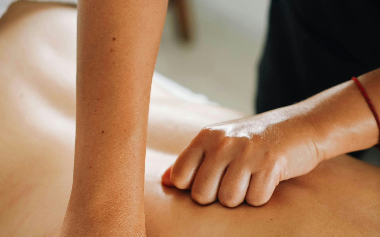 A massage therapist working through the muscles of a client's back